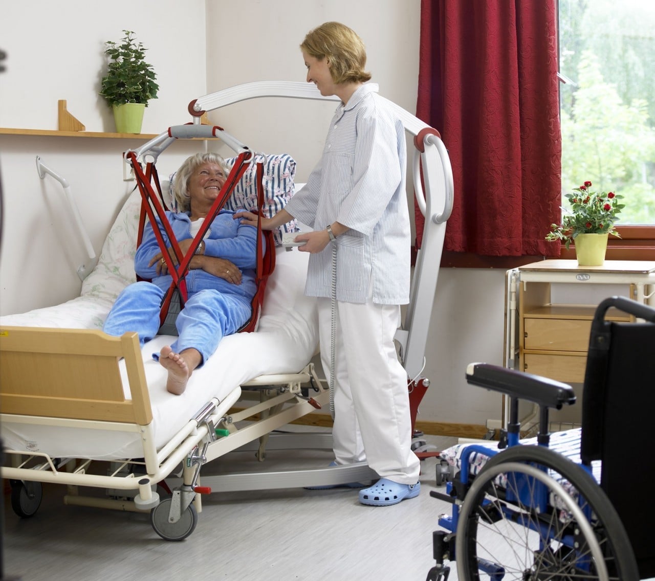 пациент на кресле каталке. уход и пересаживание инвалидов колясочников. реабилитация человека. приспособления для маломобильных больных. универсальный подъемник миник.